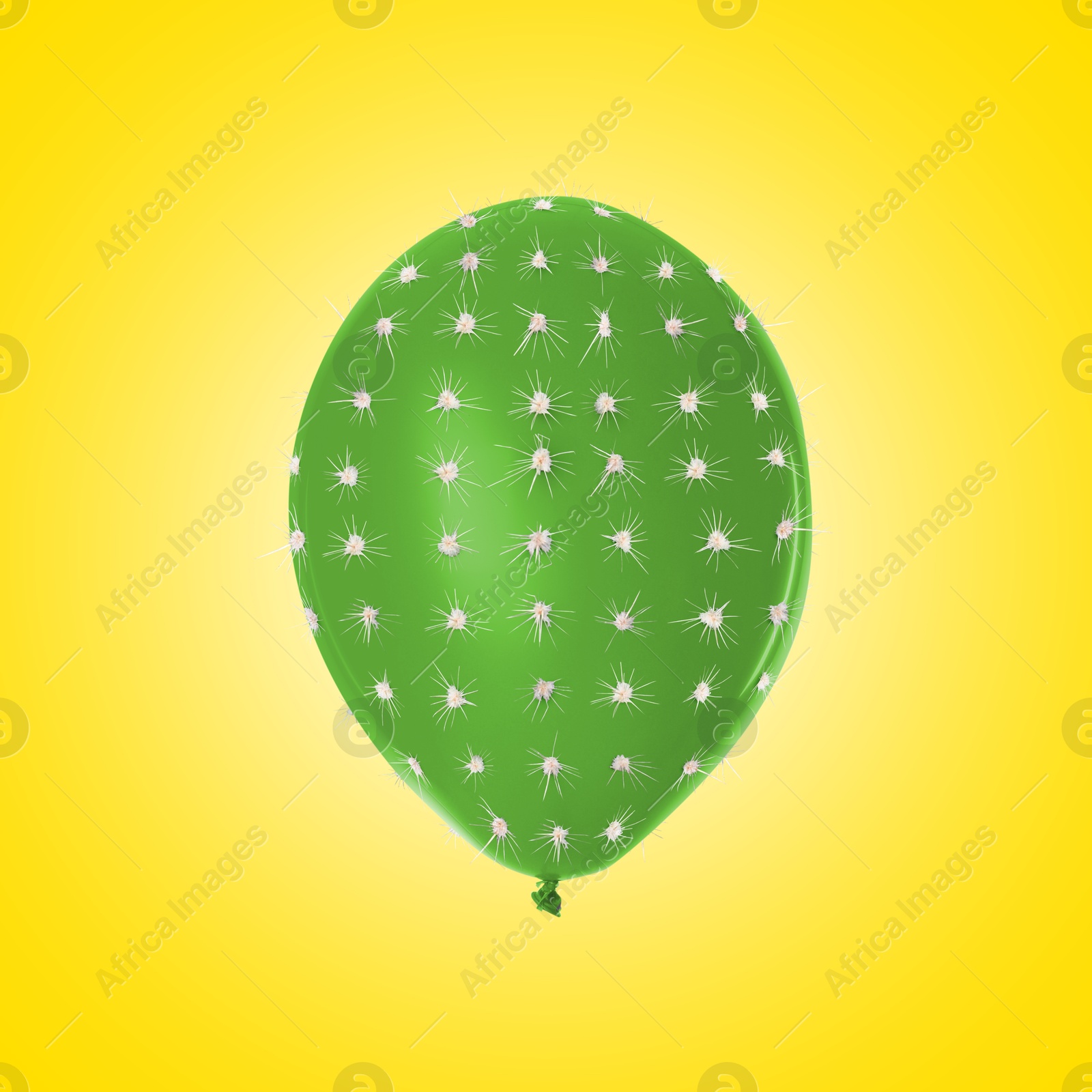 Image of Green balloon covered with cactus prickles on yellow background