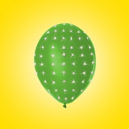 Image of Green balloon covered with cactus prickles on yellow background