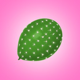Image of Green balloon covered with cactus prickles on pink gradient background