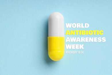 Image of World antibiotic awareness week. One pill on light blue background, top view