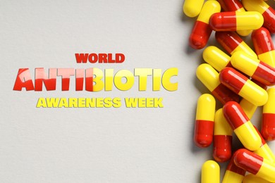 Image of World antibiotic awareness week. Many pills on light background, flat lay