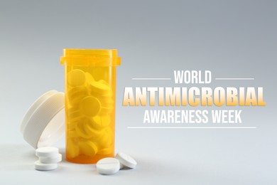 Image of World antibiotic awareness week. Bottle and scattered pills on grey background