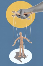 Image of Man pulling strings of puppet on color background, closeup. Creative artwork