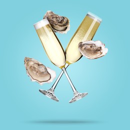 Image of Sparkling wine in glasses and fresh oysters falling on light blue background