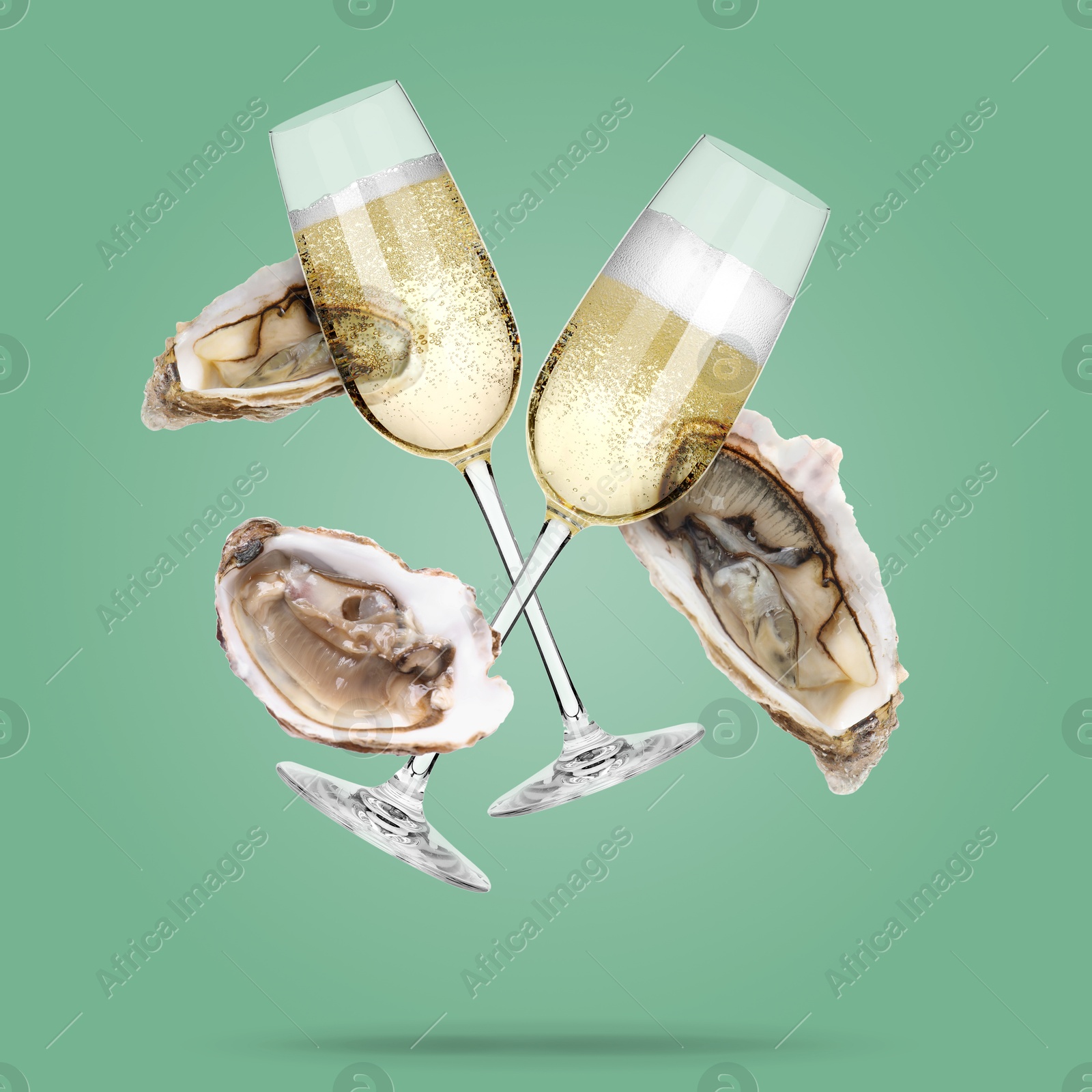Image of Sparkling wine in glasses and fresh oysters falling on aquamarine color background