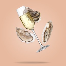 Image of Sparkling wine in glass and fresh oysters falling on pink beige background