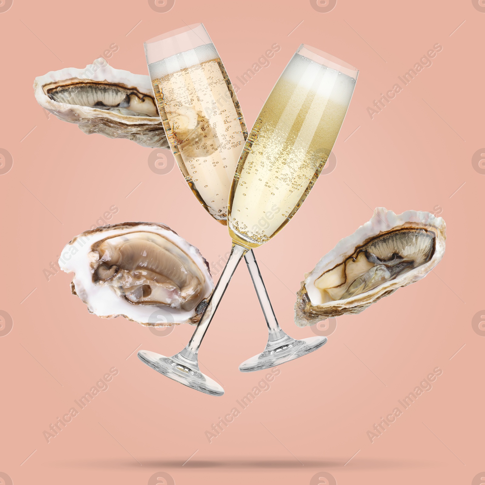 Image of Sparkling wine in glasses and fresh oysters falling on pink beige background