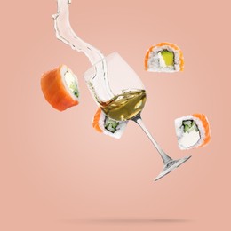 Image of Wine in glass and sushi rolls falling on pink beige background