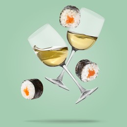 Image of White wine in glasses and sushi rolls falling on green grey color background