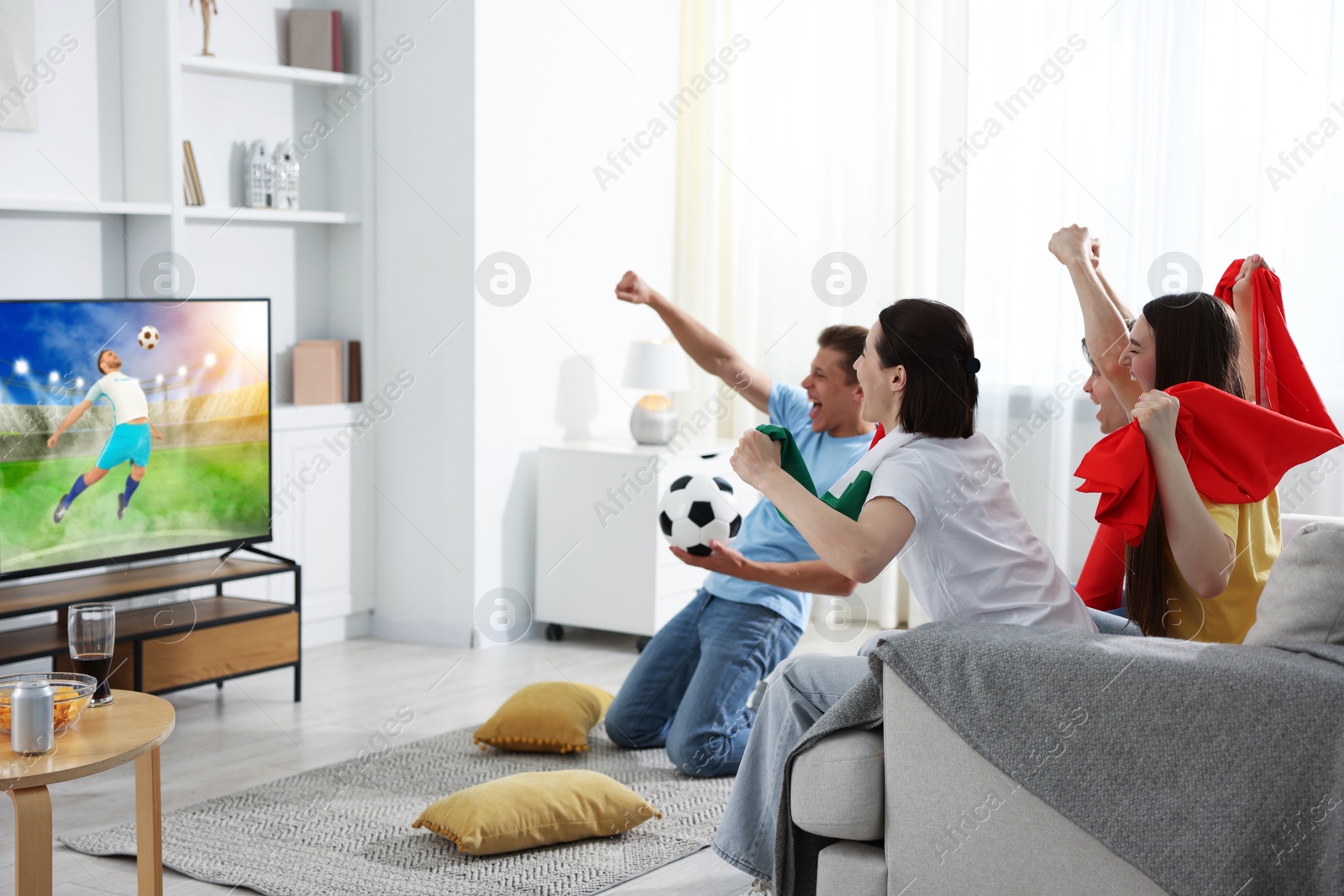 Image of Football fans watching soccer match on TV set at home