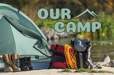 Image of Our camp, summer vacation. Tent and tourist equipment near river in nature
