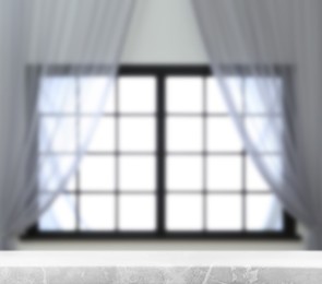 Image of Empty marble table against window with curtains in room