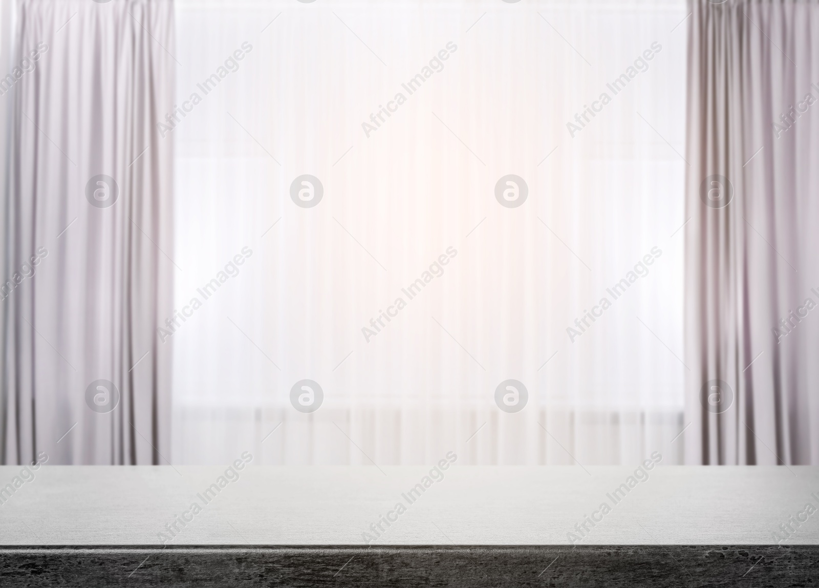 Empty stone table against window with curtains in room Image of Empty stone table against window with curtains in room