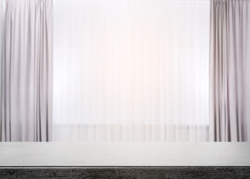 Image of Empty stone table against window with curtains in room