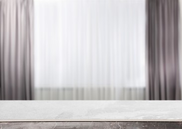 Image of Empty stone table against window with curtains in room