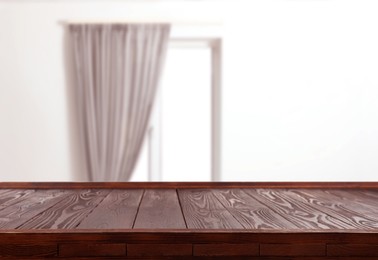 Image of Empty wooden table against window with curtain in room