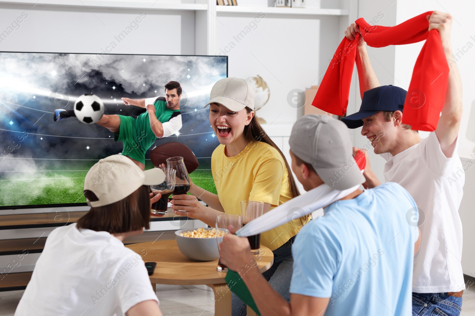 Image of Football fans watching soccer match on TV set at home