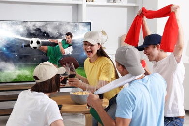 Image of Football fans watching soccer match on TV set at home