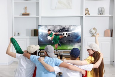 Image of Football fans watching soccer match on TV set at home