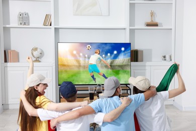 Image of Football fans watching soccer match on TV set at home