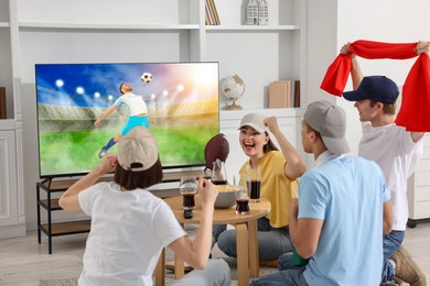 Image of Football fans watching soccer match on TV set at home