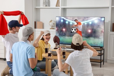 Image of Football fans watching soccer match on TV set at home