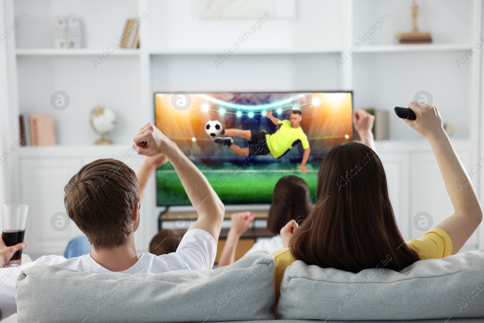 Image of Football fans watching soccer match on TV set at home, back view