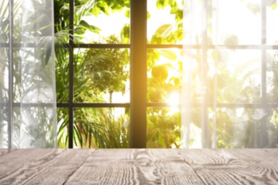 Image of Empty wooden table against window with curtains in room