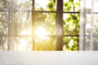 Image of Empty white table against window with curtains in room