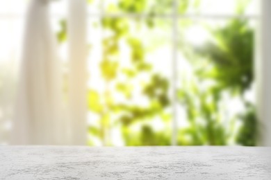 Image of Empty white table against window with curtains in room