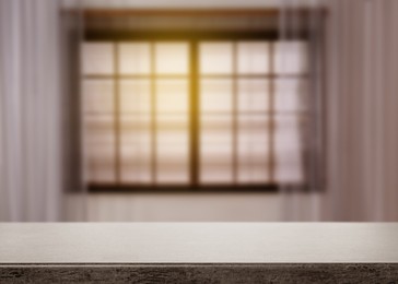 Image of Empty grey table against window with curtains in room