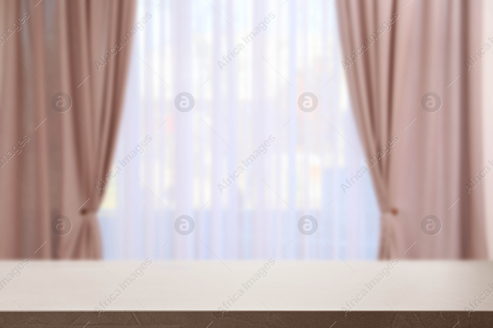 Image of Empty table against window with curtains in room
