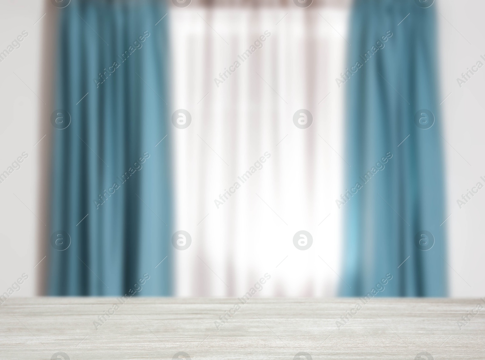 Image of Empty white wooden table against window with curtains in room