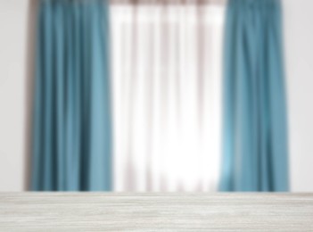 Image of Empty white wooden table against window with curtains in room