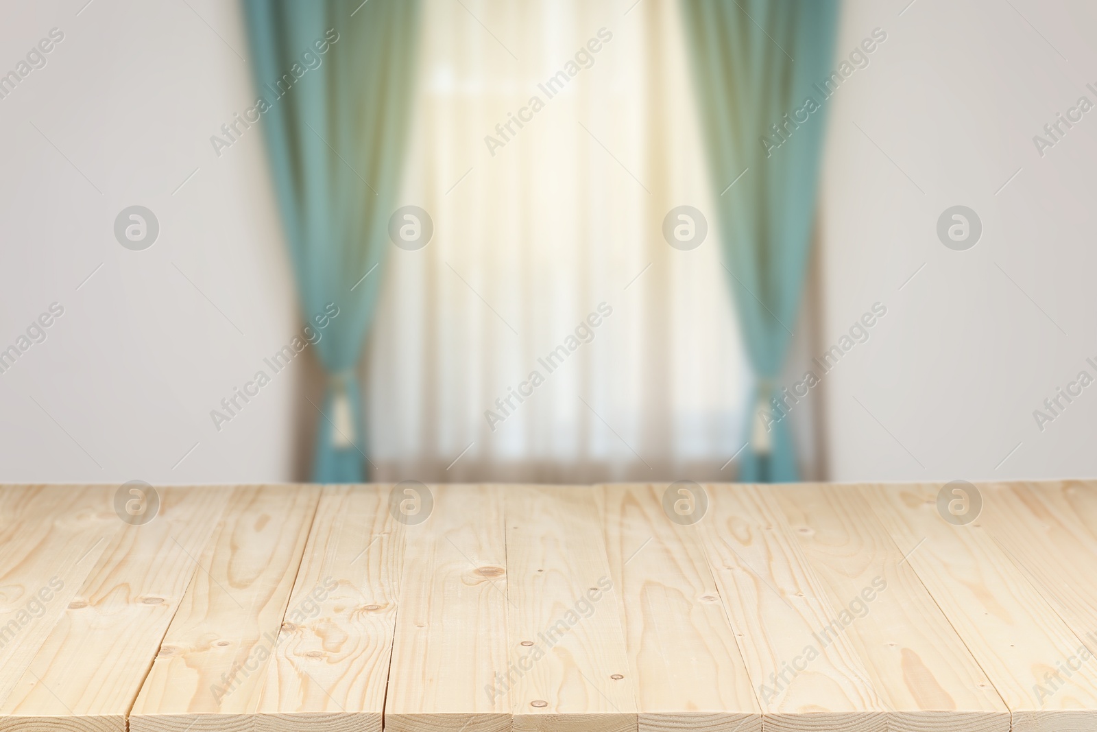 Image of Empty wooden table against window with curtains in room