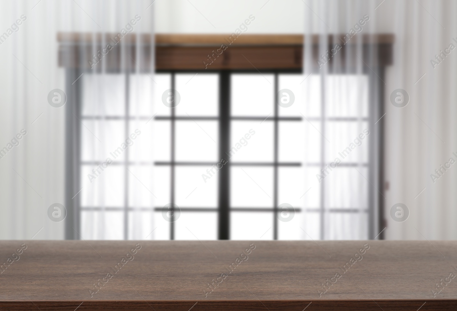Image of Empty wooden table against window with curtains in room