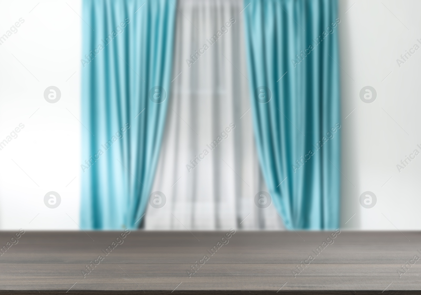 Image of Empty wooden table against window with curtains in room