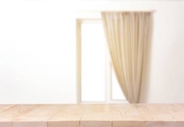 Image of Empty wooden table against window with curtain in room
