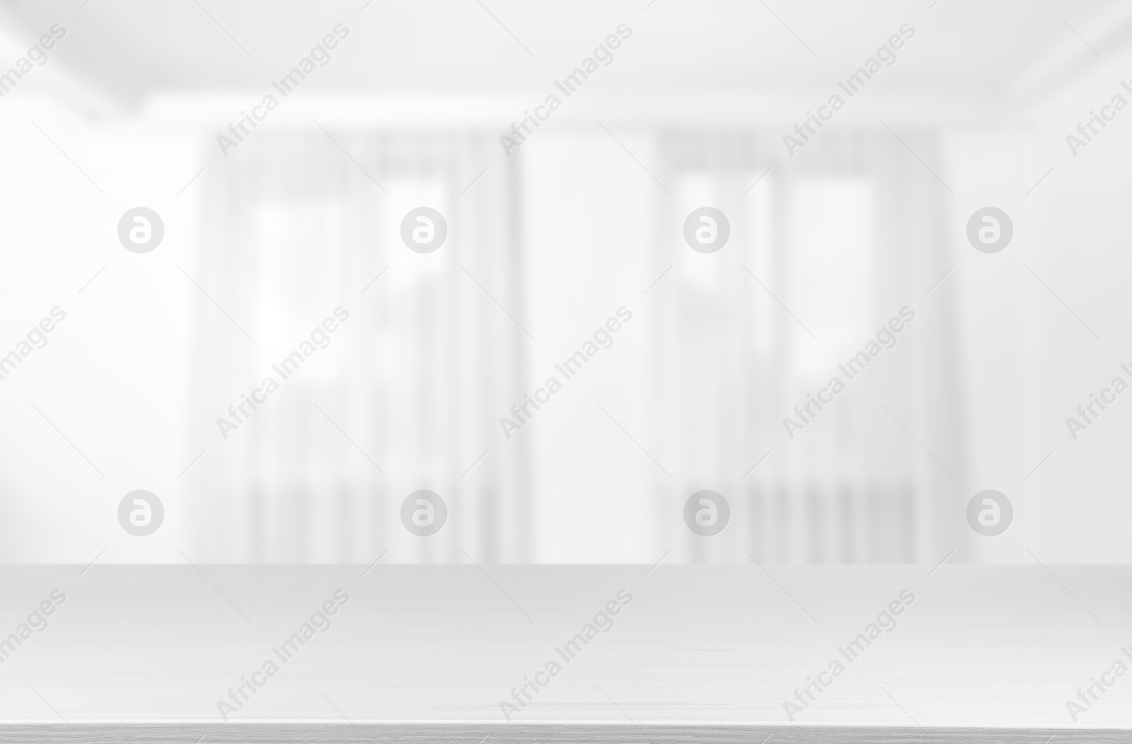 Image of Empty white table against windows with curtains in room