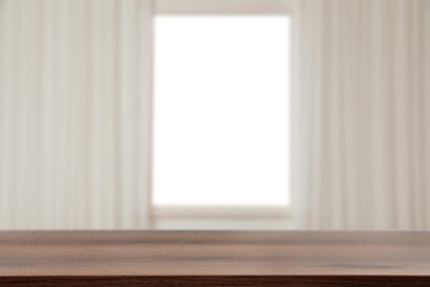 Image of Empty wooden table against window with curtains in room