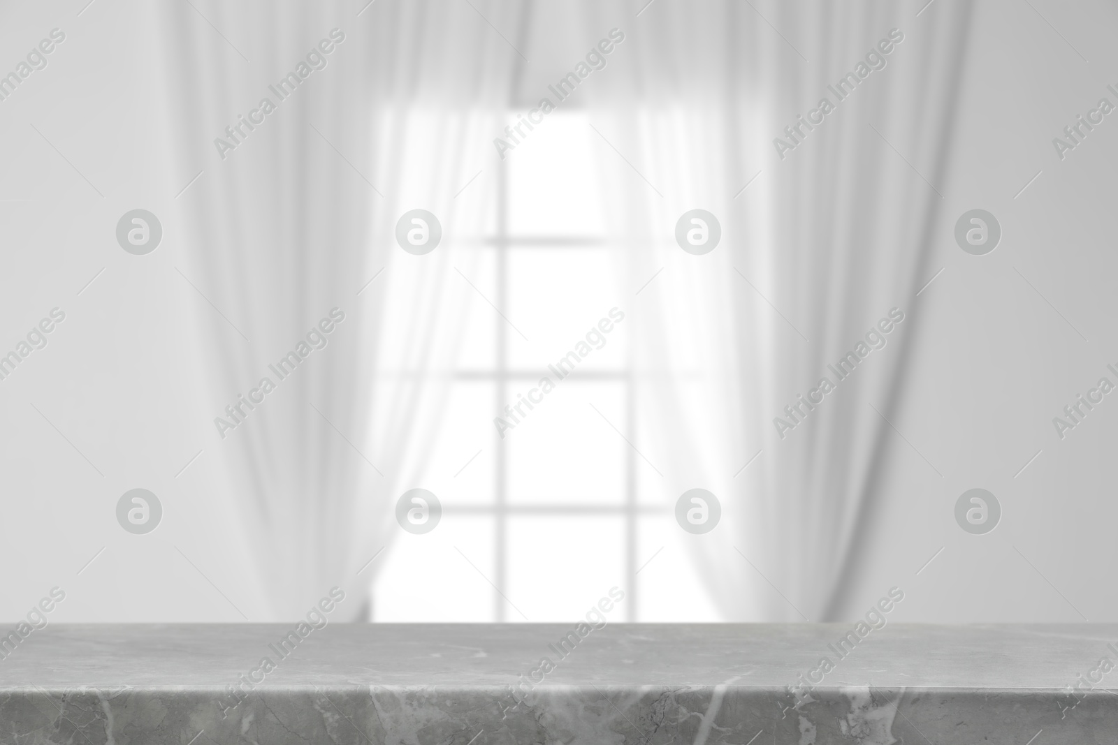 Image of Empty grey marble table against window with curtains in room