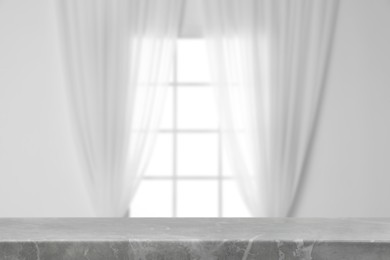 Image of Empty grey marble table against window with curtains in room