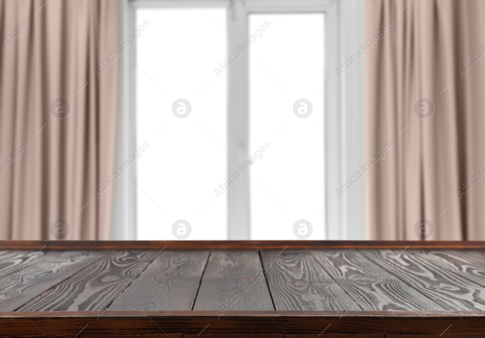 Image of Empty wooden table against window with curtains in room