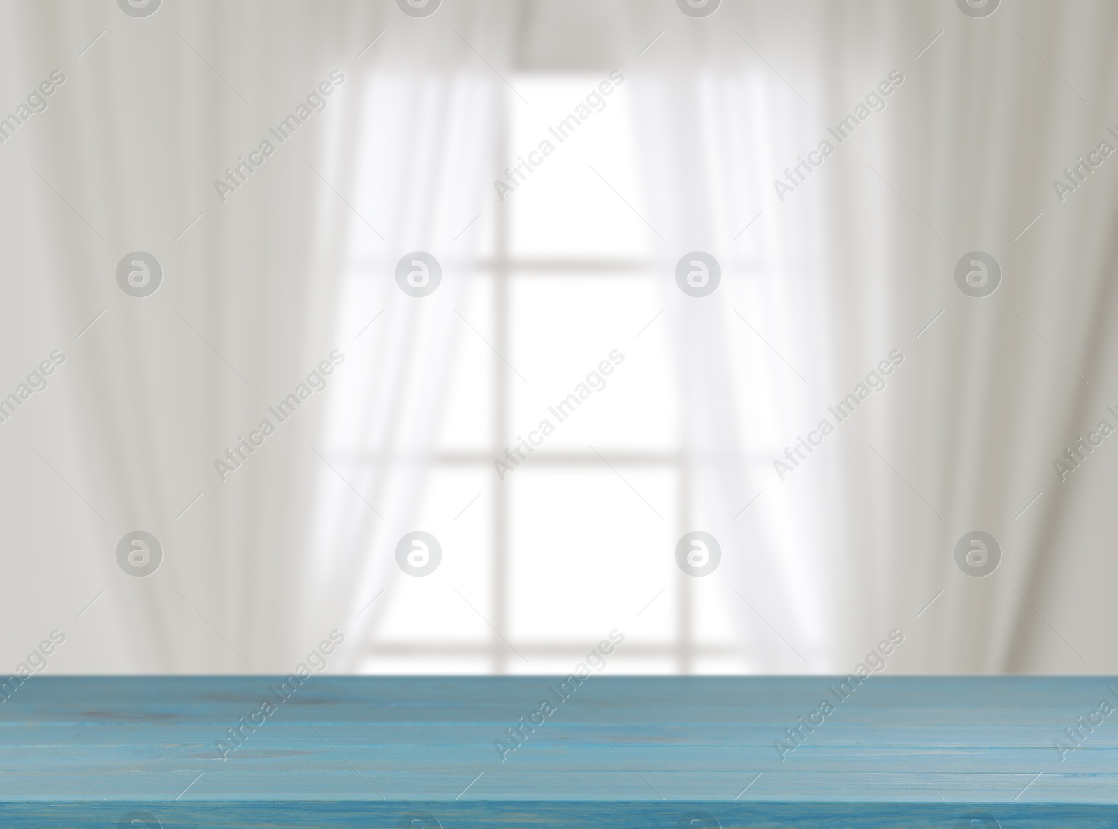 Image of Empty wooden table against window with curtains in room