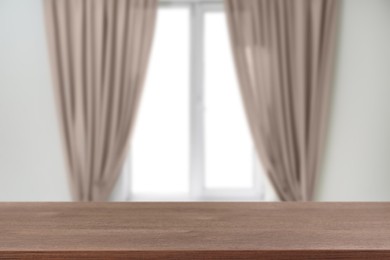 Image of Empty wooden table against window with curtains in room