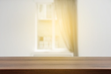 Image of Empty wooden table against window with curtain in room