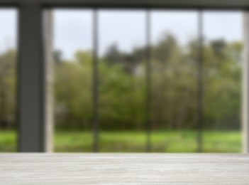 Image of Empty wooden table against window in room