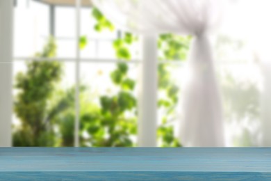 Image of Empty wooden table against window with curtain in room