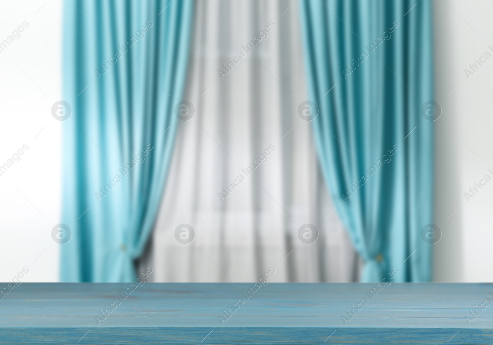 Image of Empty wooden table against window with curtains in room