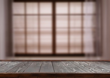 Image of Empty wooden table against window in room